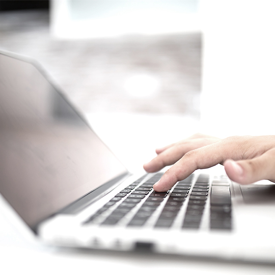 hand typing in a laptop